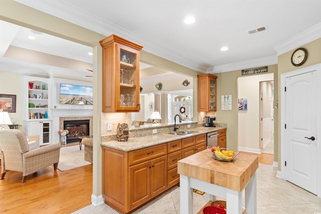 60 Springtime Ct, Murrells Inlet, SC 29576 - kitchen with crown molding, glass insert cabinets, stainless steel dishwasher, light stone countertops, and a glass covered fireplace