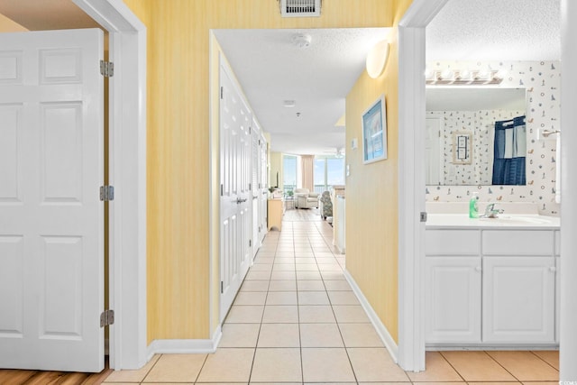 5310 N Ocean Blvd Unit 7C, North Myrtle Beach, SC 29582 - hallway with wallpapered walls, light tile patterned flooring, and a textured ceiling