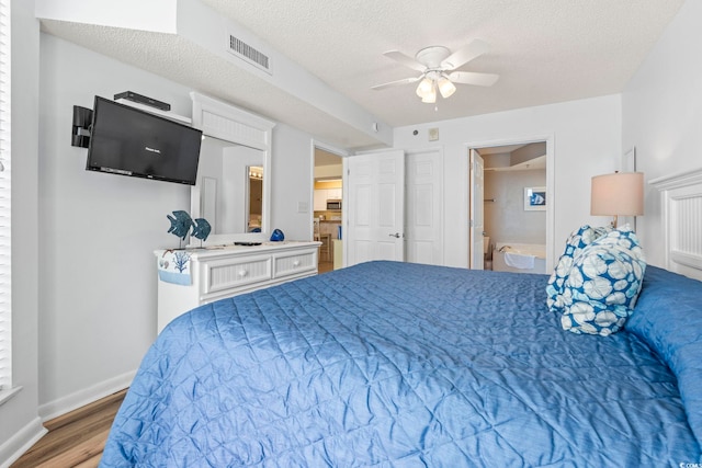 5310 N Ocean Blvd Unit 7C, North Myrtle Beach, SC 29582 - bedroom featuring wood finished floors, a textured ceiling, ceiling fan, and ensuite bath