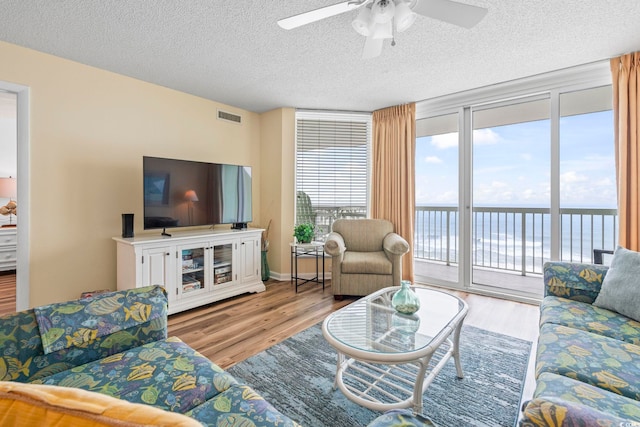 5310 N Ocean Blvd Unit 7C, North Myrtle Beach, SC 29582 - living area featuring ceiling fan, a textured ceiling, and wood finished floors