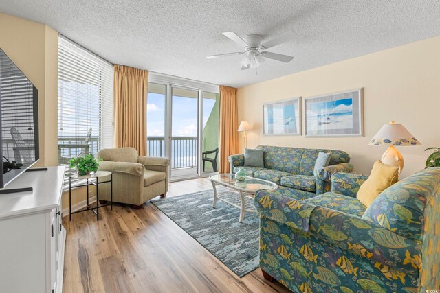 5310 N Ocean Blvd Unit 7C, North Myrtle Beach, SC 29582 - living area featuring a ceiling fan, light wood-type flooring, and a textured ceiling