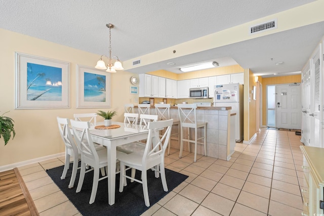 5310 N Ocean Blvd Unit 7C, North Myrtle Beach, SC 29582 - dining area with light tile patterned floors, a chandelier, and a textured ceiling