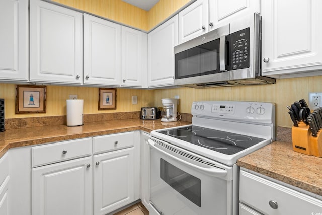 5310 N Ocean Blvd Unit 7C, North Myrtle Beach, SC 29582 - kitchen featuring white range with electric cooktop, stainless steel microwave, and white cabinets