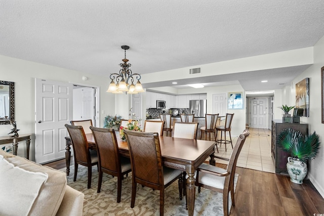 2151 Bridgeview Ct Unit 3-404, North Myrtle Beach, SC 29582 - dining room with a chandelier, wood finished floors, and a textured ceiling