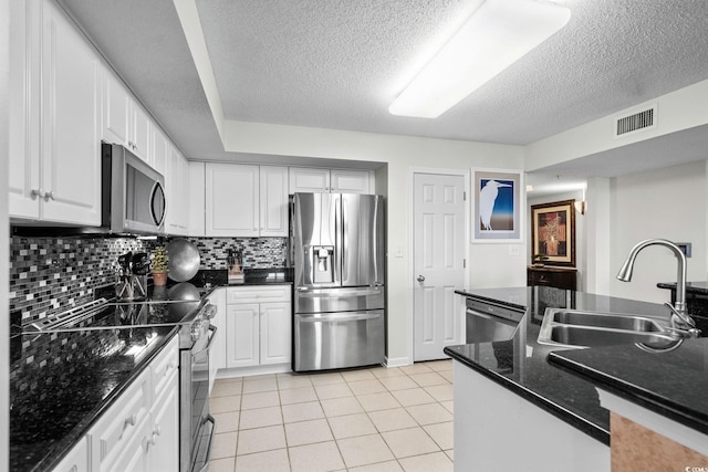 2151 Bridgeview Ct Unit 3-404, North Myrtle Beach, SC 29582 - kitchen featuring stainless steel appliances, a textured ceiling, white cabinetry, backsplash, and light tile patterned flooring