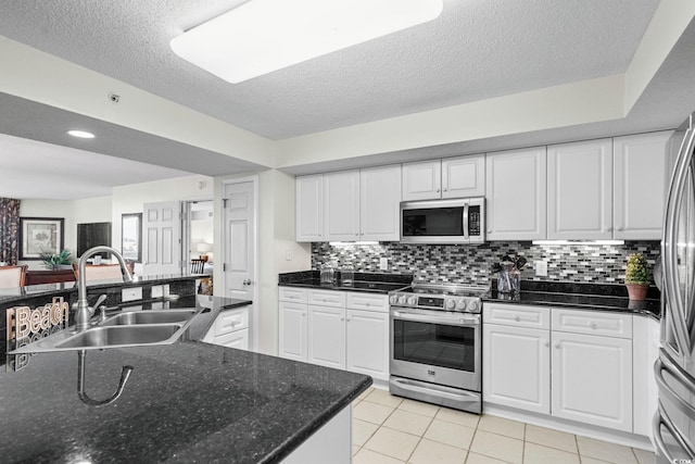 2151 Bridgeview Ct Unit 3-404, North Myrtle Beach, SC 29582 - kitchen featuring appliances with stainless steel finishes, white cabinets, decorative backsplash, and a textured ceiling