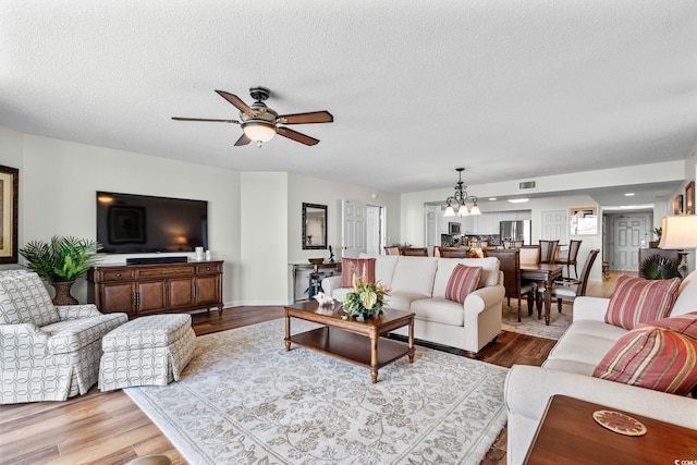2151 Bridgeview Ct Unit 3-404, North Myrtle Beach, SC 29582 - living area with a ceiling fan, a chandelier, wood finished floors, and a textured ceiling