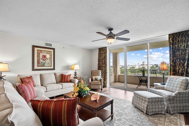 2151 Bridgeview Ct Unit 3-404, North Myrtle Beach, SC 29582 - living area with wood finished floors, a ceiling fan, a wall of windows, and a textured ceiling