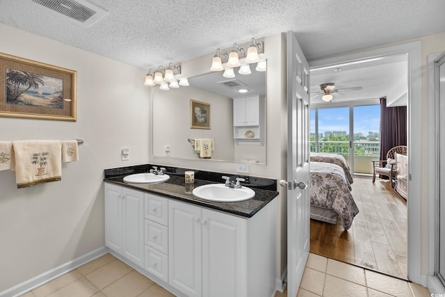 2151 Bridgeview Ct Unit 3-404, North Myrtle Beach, SC 29582 - bathroom featuring double vanity, a textured ceiling, connected bathroom, ceiling fan, and tile patterned flooring