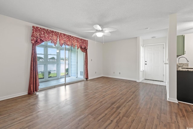 2122 Clearwater Dr Unit C, Surfside Beach, SC 29575 - empty room featuring wood finished floors, a textured ceiling, ceiling fan, and a water view