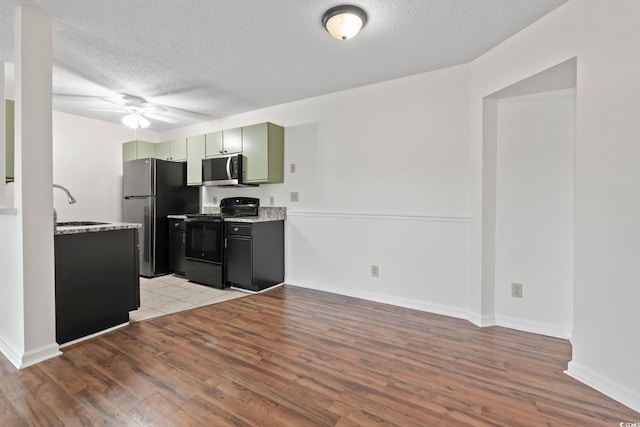 2122 Clearwater Dr Unit C, Surfside Beach, SC 29575 - kitchen featuring stainless steel appliances, ceiling fan, light wood-style floors, a textured ceiling, and green cabinets