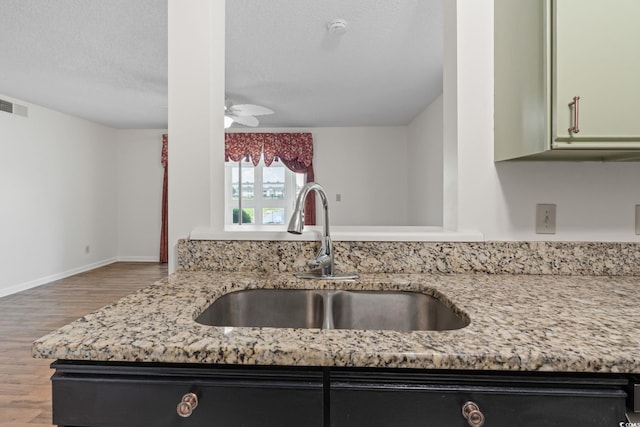 2122 Clearwater Dr Unit C, Surfside Beach, SC 29575 - kitchen featuring wood finished floors, light stone countertops, a textured ceiling, and ceiling fan
