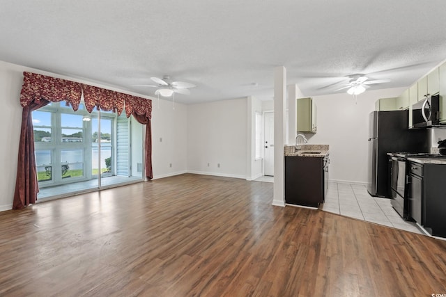 2122 Clearwater Dr Unit C, Surfside Beach, SC 29575 - kitchen featuring appliances with stainless steel finishes, a ceiling fan, light wood finished floors, a textured ceiling, and a water view