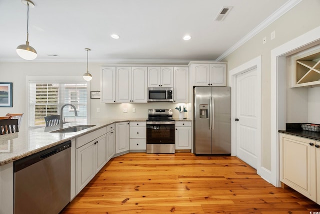 43 Sandlapper Way, Pawleys Island, SC 29585 - kitchen with stainless steel appliances, crown molding, hanging light fixtures, light stone countertops, and light wood-style flooring