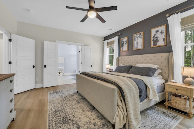 141 Evans Branch Ct, Galivants Ferry, SC 29544 - bedroom with multiple windows, light wood-style flooring, ceiling fan, and an accent wall