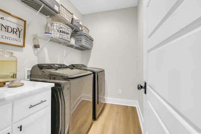 141 Evans Branch Ct, Galivants Ferry, SC 29544 - laundry area featuring washing machine and clothes dryer, light wood-type flooring, and cabinet space