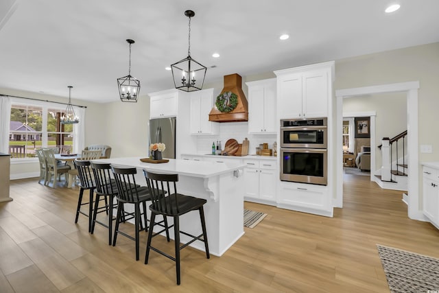 141 Evans Branch Ct, Galivants Ferry, SC 29544 - kitchen with premium range hood, appliances with stainless steel finishes, a kitchen island, decorative backsplash, and a kitchen breakfast bar