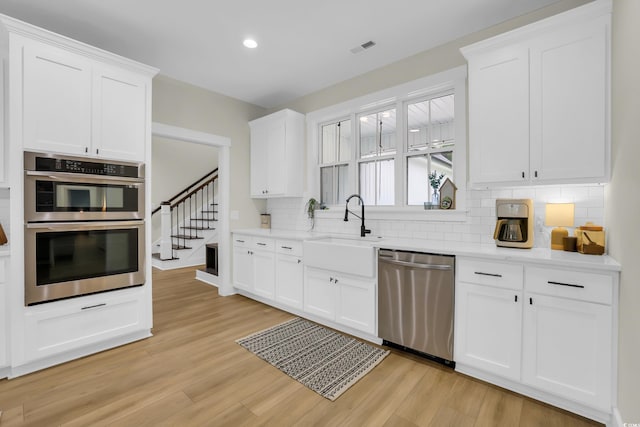 141 Evans Branch Ct, Galivants Ferry, SC 29544 - kitchen featuring stainless steel appliances, decorative backsplash, light wood-type flooring, white cabinetry, and recessed lighting