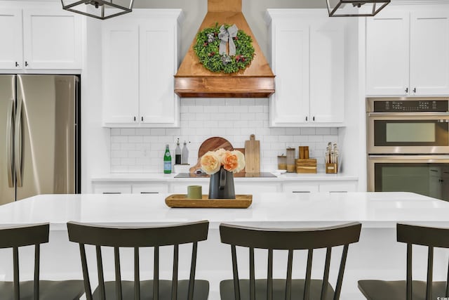 141 Evans Branch Ct, Galivants Ferry, SC 29544 - kitchen with appliances with stainless steel finishes, premium range hood, light countertops, and white cabinets