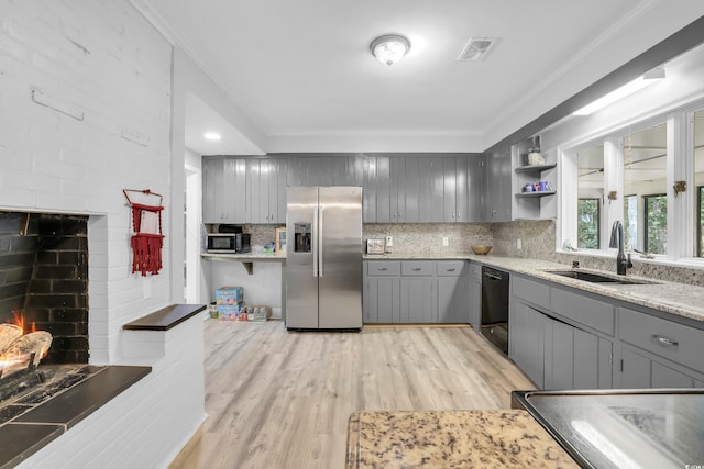 231 Live Oak Ln, Myrtle Beach, SC 29572 - kitchen with stainless steel appliances, gray cabinetry, a brick fireplace, tasteful backsplash, and crown molding