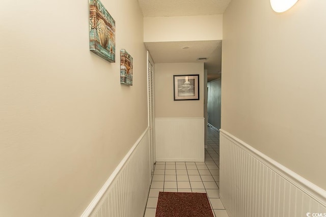 2101 S Ocean Blvd, North Myrtle Beach, SC 29582 - hall with a wainscoted wall, tile patterned flooring, and a decorative wall