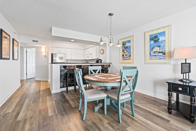 2001 S Ocean Blvd Unit 901, North Myrtle Beach, SC 29582 - dining room with wood finished floors and a textured ceiling