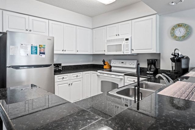 2001 S Ocean Blvd Unit 901, North Myrtle Beach, SC 29582 - kitchen featuring white appliances, white cabinetry, and a textured ceiling