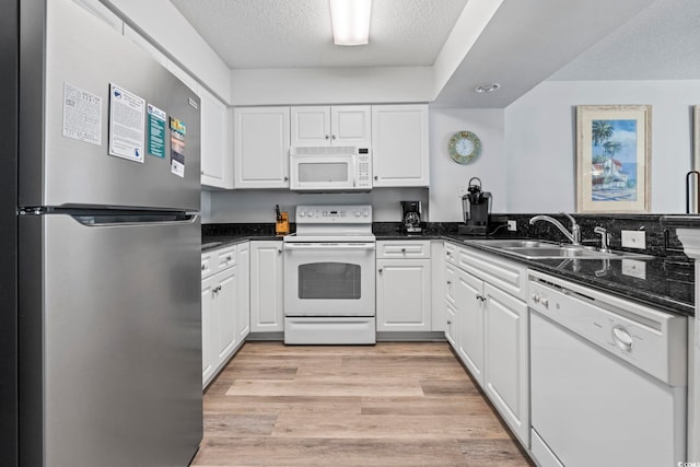 2001 S Ocean Blvd Unit 901, North Myrtle Beach, SC 29582 - kitchen with white appliances, white cabinetry, a textured ceiling, and light wood-style floors
