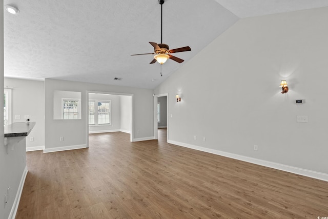 3845 Camden Dr, Myrtle Beach, SC 29588 - unfurnished living room with wood finished floors, ceiling fan, and high vaulted ceiling