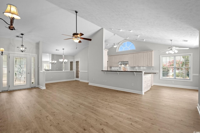 3845 Camden Dr, Myrtle Beach, SC 29588 - unfurnished living room with a ceiling fan, light wood-type flooring, a chandelier, high vaulted ceiling, and a textured ceiling