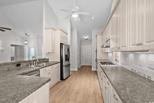 3845 Camden Dr, Myrtle Beach, SC 29588 - kitchen with ceiling fan, stainless steel appliances, vaulted ceiling, dark countertops, and light wood finished floors