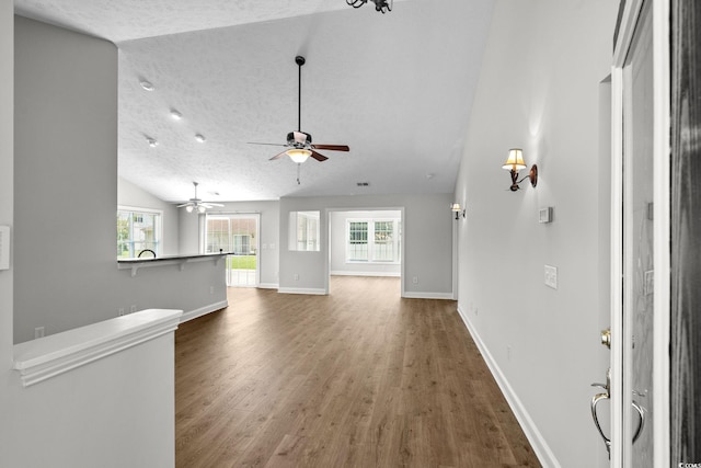 3845 Camden Dr, Myrtle Beach, SC 29588 - unfurnished living room featuring wood finished floors, vaulted ceiling, and a ceiling fan