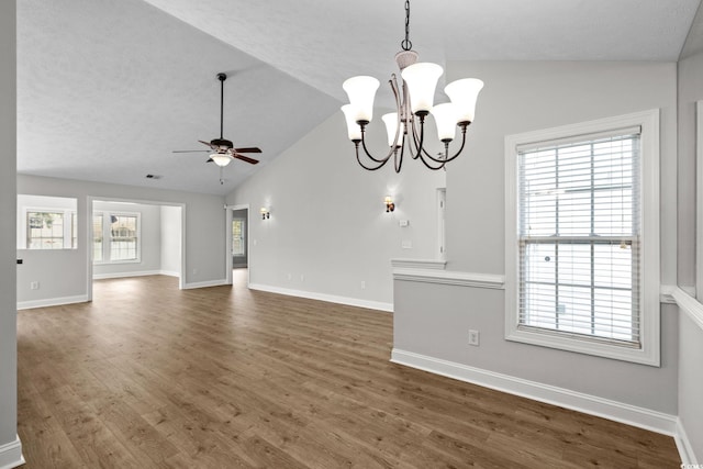 3845 Camden Dr, Myrtle Beach, SC 29588 - unfurnished living room with vaulted ceiling, a ceiling fan, wood finished floors, and a chandelier
