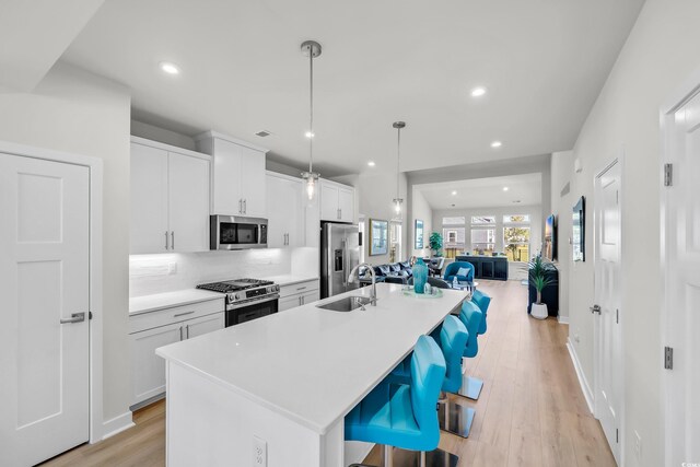 8906 Freya Way Unit 24A, Longs, SC 29568 - kitchen with stainless steel appliances, an island with sink, open floor plan, a kitchen bar, and light wood finished floors