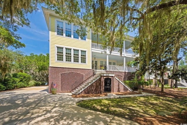 3085 Luvan Blvd, Georgetown, SC 29440 - view of front of home with stairs, brick siding, driveway, and a balcony