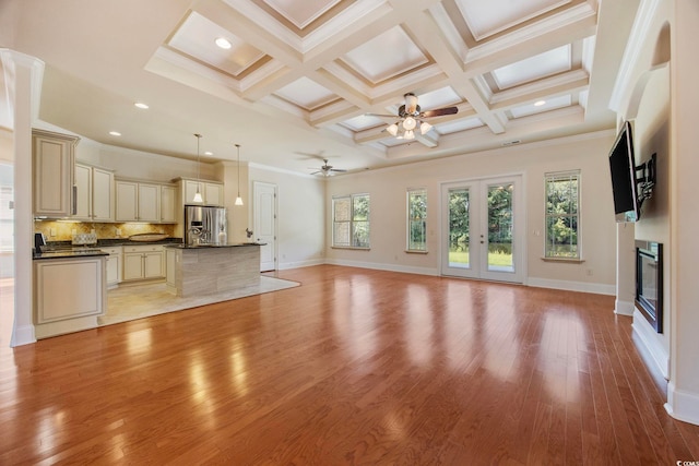 8444 Juxa Dr, Myrtle Beach, SC 29579 - unfurnished living room featuring a ceiling fan, light wood finished floors, a glass covered fireplace, crown molding, and beam ceiling
