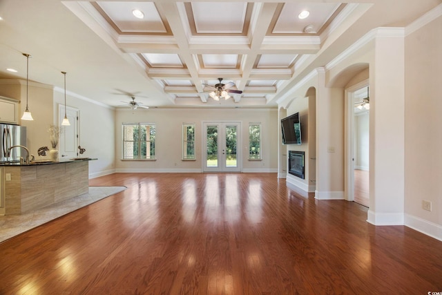 8444 Juxa Dr, Myrtle Beach, SC 29579 - unfurnished living room featuring a ceiling fan, a glass covered fireplace, wood finished floors, beamed ceiling, and ornamental molding