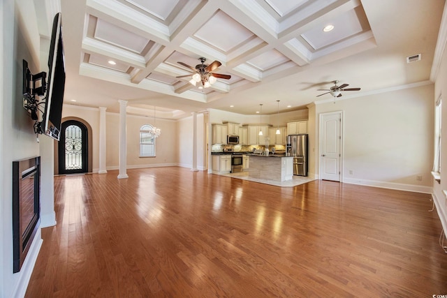 8444 Juxa Dr, Myrtle Beach, SC 29579 - unfurnished living room featuring ornate columns, a ceiling fan, ornamental molding, a glass covered fireplace, and coffered ceiling