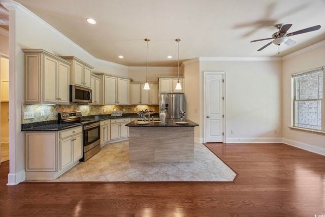 8444 Juxa Dr, Myrtle Beach, SC 29579 - kitchen with appliances with stainless steel finishes, cream cabinets, light wood finished floors, backsplash, and crown molding