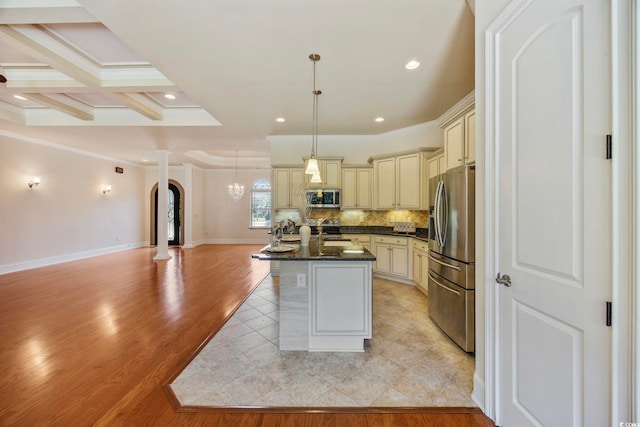 8444 Juxa Dr, Myrtle Beach, SC 29579 - kitchen featuring cream cabinetry, appliances with stainless steel finishes, open floor plan, crown molding, and backsplash