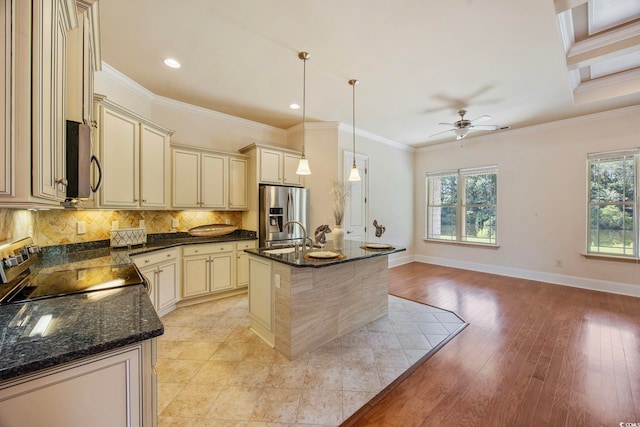 8444 Juxa Dr, Myrtle Beach, SC 29579 - kitchen with cream cabinets, appliances with stainless steel finishes, healthy amount of natural light, decorative backsplash, and crown molding