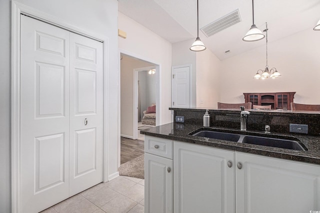 4530 Lighthouse Dr Unit 31-C, Little River, SC 29566 - kitchen with white cabinets, light tile patterned floors, pendant lighting, dark stone counters, and lofted ceiling