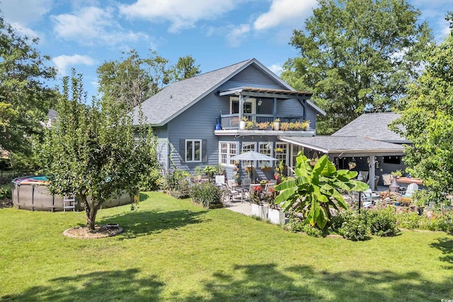 106 Furman Cir, Conway, SC 29526 - back of house featuring a balcony, an outdoor pool, a yard, a patio area, and a shingled roof