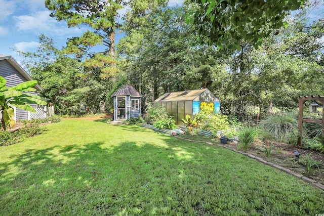 106 Furman Cir, Conway, SC 29526 - view of green lawn featuring a greenhouse, an outdoor structure, a vegetable garden, and view of scattered trees