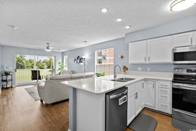 613 Waterway Village Blvd Unit 4-F, Myrtle Beach, SC 29579 - kitchen with stainless steel appliances, light countertops, wood finished floors, white cabinets, and a textured ceiling