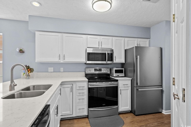 613 Waterway Village Blvd Unit 4-F, Myrtle Beach, SC 29579 - kitchen featuring stainless steel appliances, white cabinets, dark wood-style flooring, and a textured ceiling