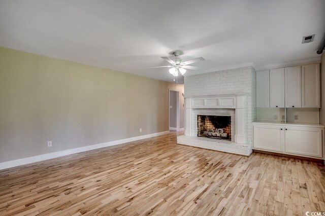 414 Dunes Dr, Myrtle Beach, SC 29572 - unfurnished living room featuring light wood-type flooring, a ceiling fan, a fireplace, and crown molding