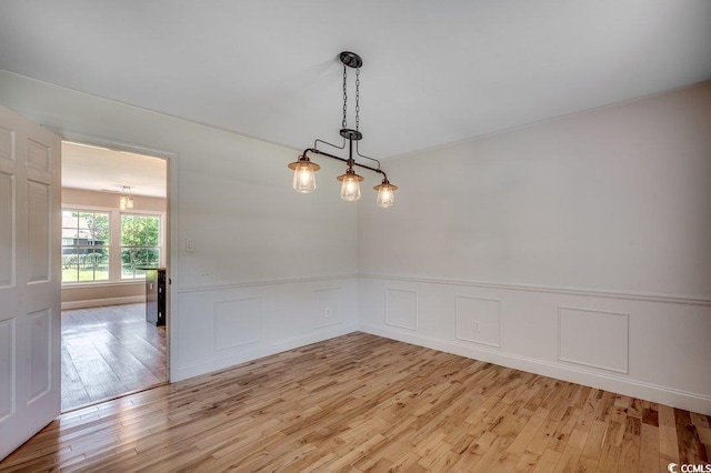 414 Dunes Dr, Myrtle Beach, SC 29572 - spare room featuring light wood-style flooring, a wainscoted wall, and a chandelier