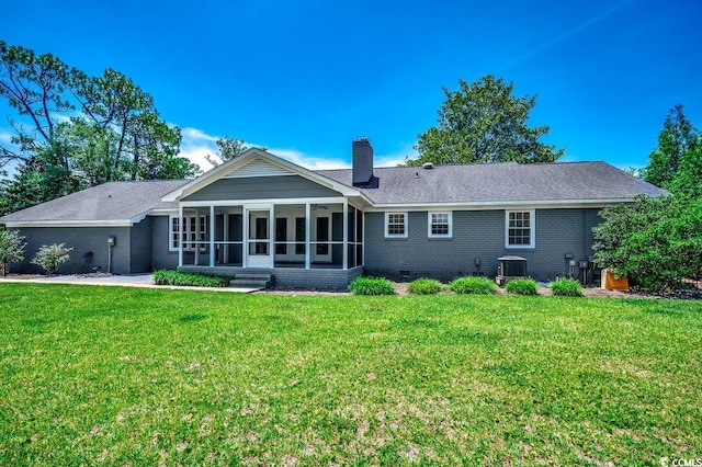 414 Dunes Dr, Myrtle Beach, SC 29572 - back of property with a sunroom, a lawn, a chimney, and brick siding