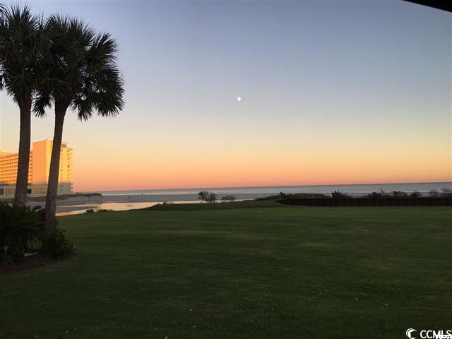 414 Dunes Dr, Myrtle Beach, SC 29572 - yard at dusk featuring a water view and a lawn